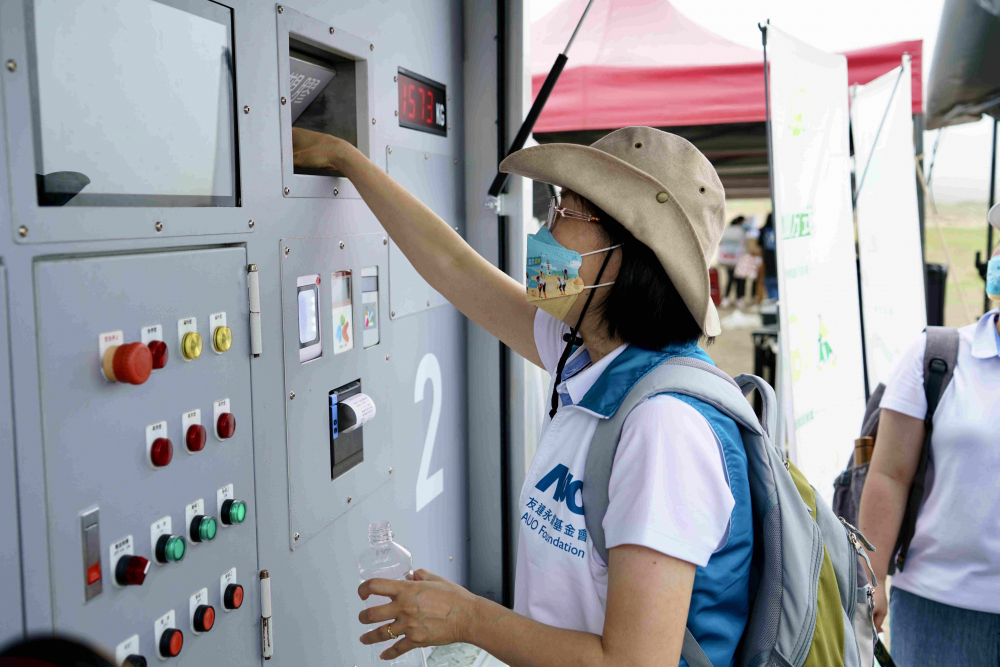 志工們將拾起的寶特瓶投入「好歸塑專車」，讓廢棄塑料空瓶可以直接粉碎、縮小體積，未來將可再製成購物袋、寶特衣、悠遊卡等生活用品